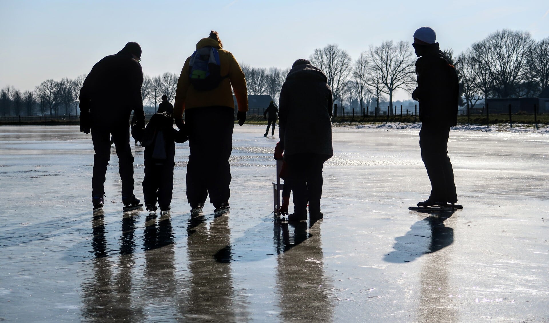 De allereerste bezoekers wagen zich vrijdagochtend op het ijs van ijsbaan Steintjesweide in Hengelo. Foto: Luuk Stam
