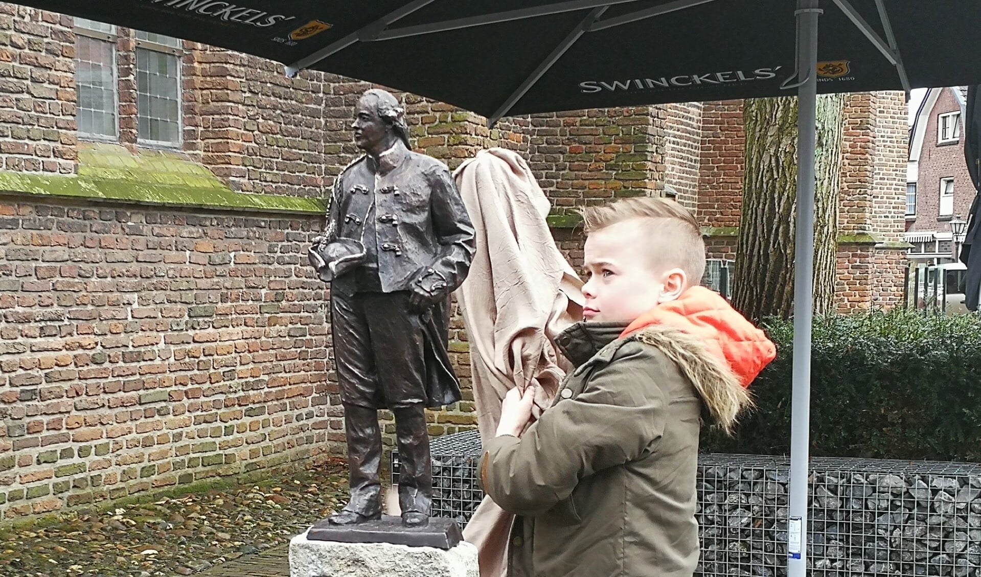 De vijfde generatie 'Willem' Nieuwenhuis, zoon Marc Cornelis Willem, onthult het beeld van Willem V. Foto: Rob Weeber