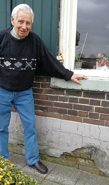Willem Reurslag bij het gat in de gevel van de boerderij door Messerschmitt-kogels. Foto: Rob Weeber