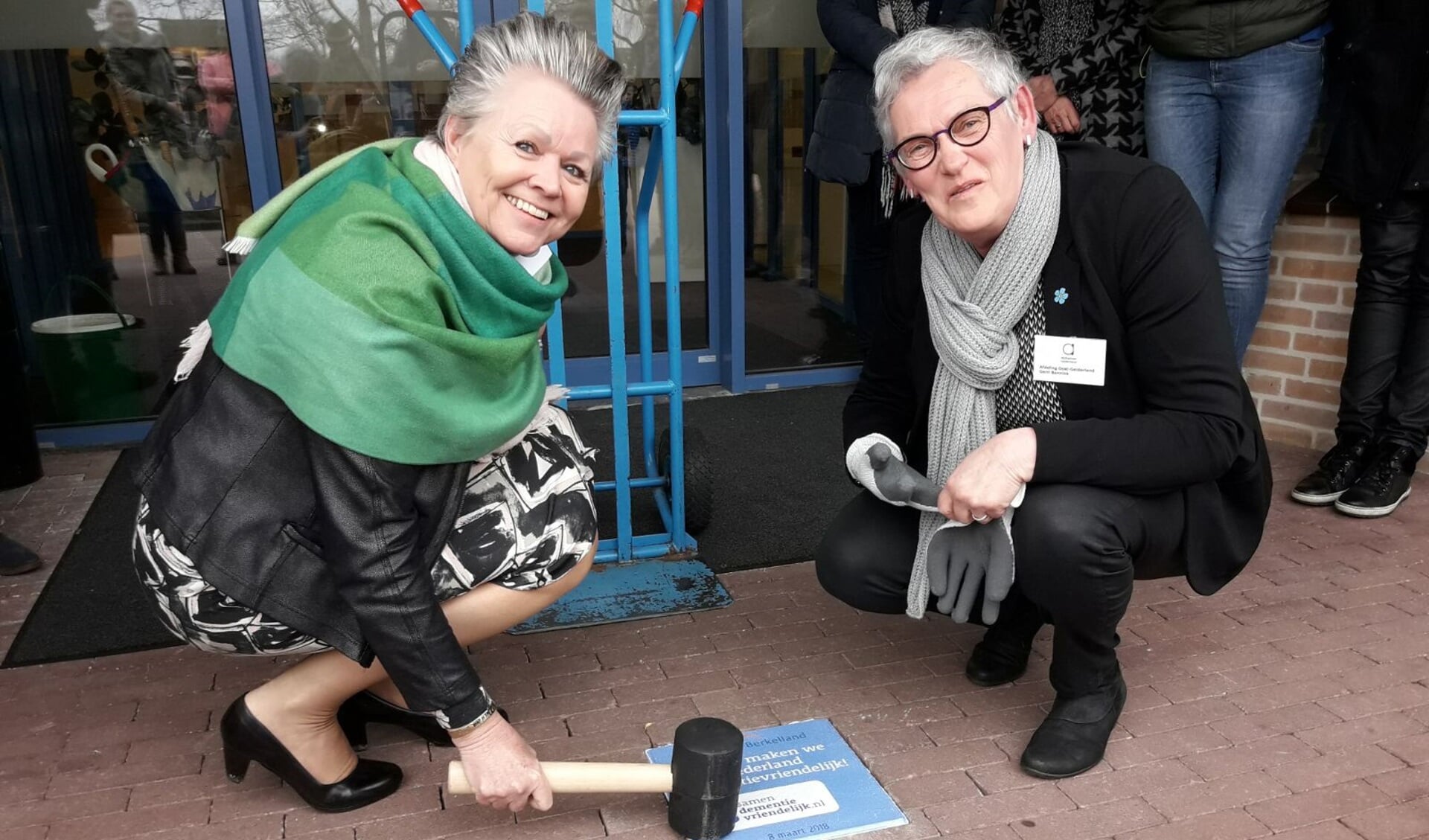 Wethouder Marijke van Haaren en Gerri Bannink leggen de tegel. Foto: Gemeente Berkelland