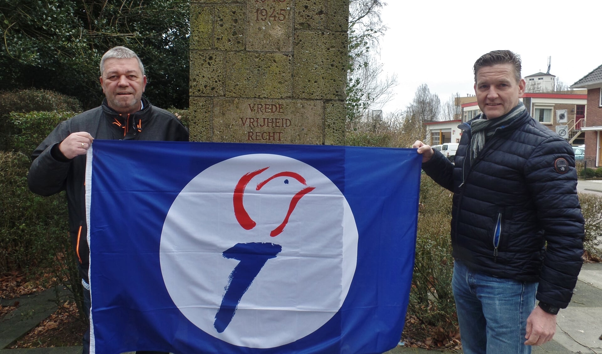 Theo Leemreize en Walter Leemreize met de vrijheidsvlag bij het oorlogsmonument.