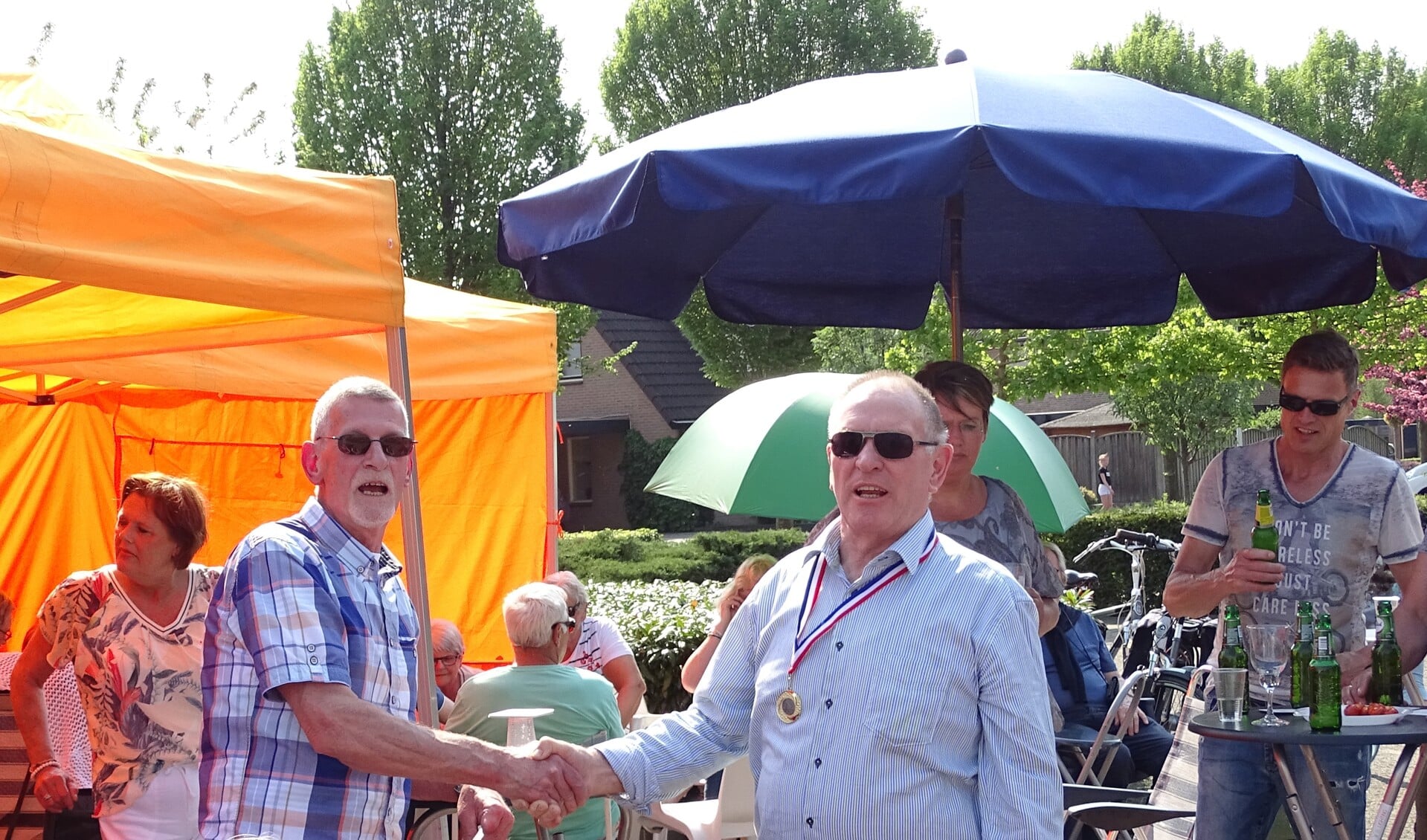 Voorzitter Bart de Rouw van de buurtvereniging overhandigde de medaille aan Jan Klein Kranenbarg. Foto: PR. 