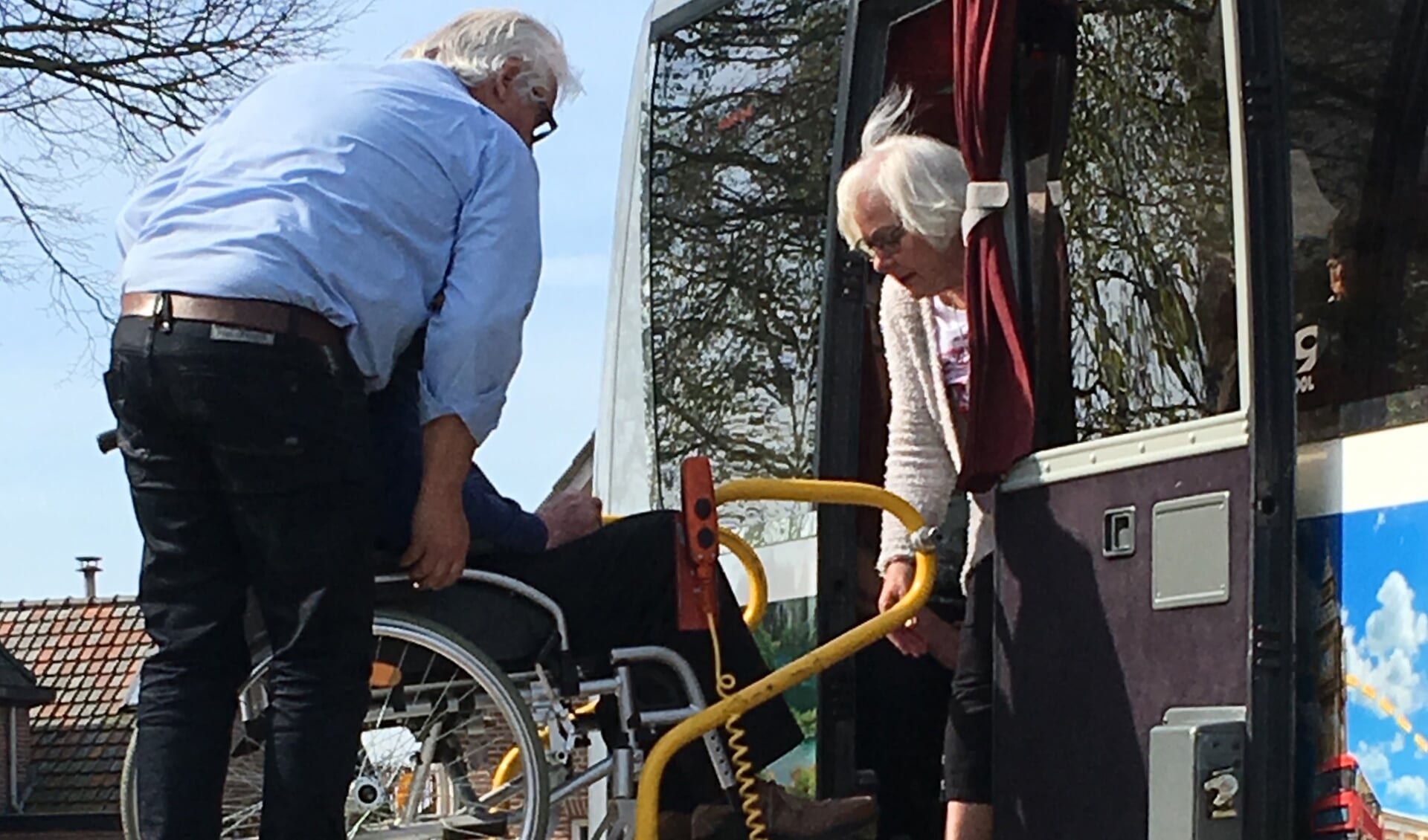 Helpende handen bij het instappen van de bus. Foto: Trudi van der Weiden