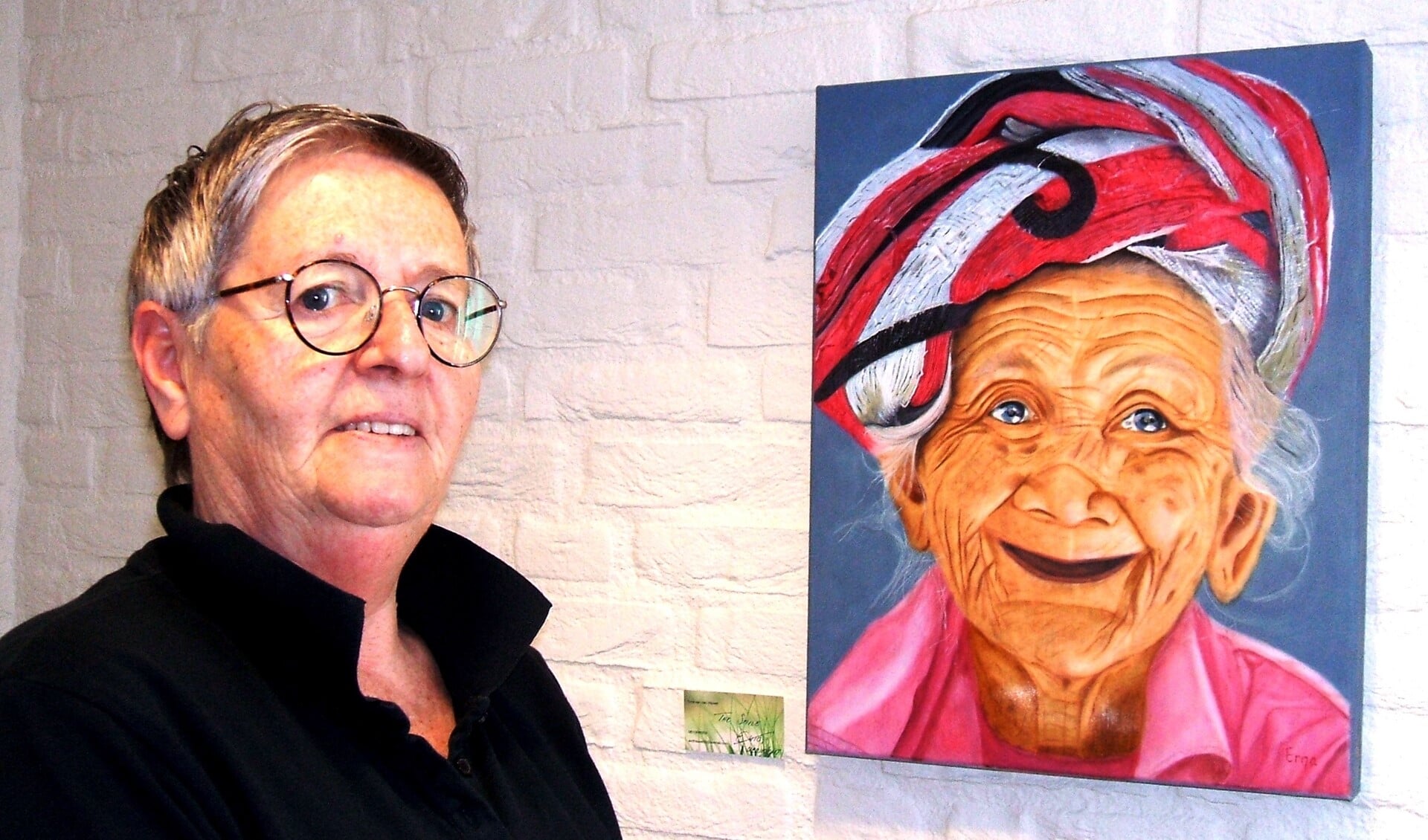 Erna van den Heuvel met haar werk ‘The Smile’, geportretteerd in het oude Rabobankgebouw in Varsseveld. Foto: Reinier Kroesen