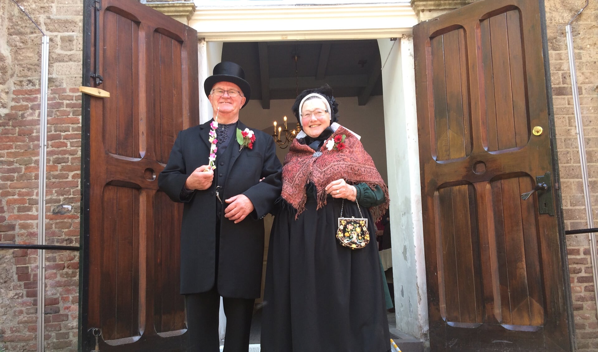 Gerrie en Gerrit Harmsen in folklorekleding voor de Sint Martinuskerk in Warnsveld waarvan Gerrit koster is. Foto: PR
