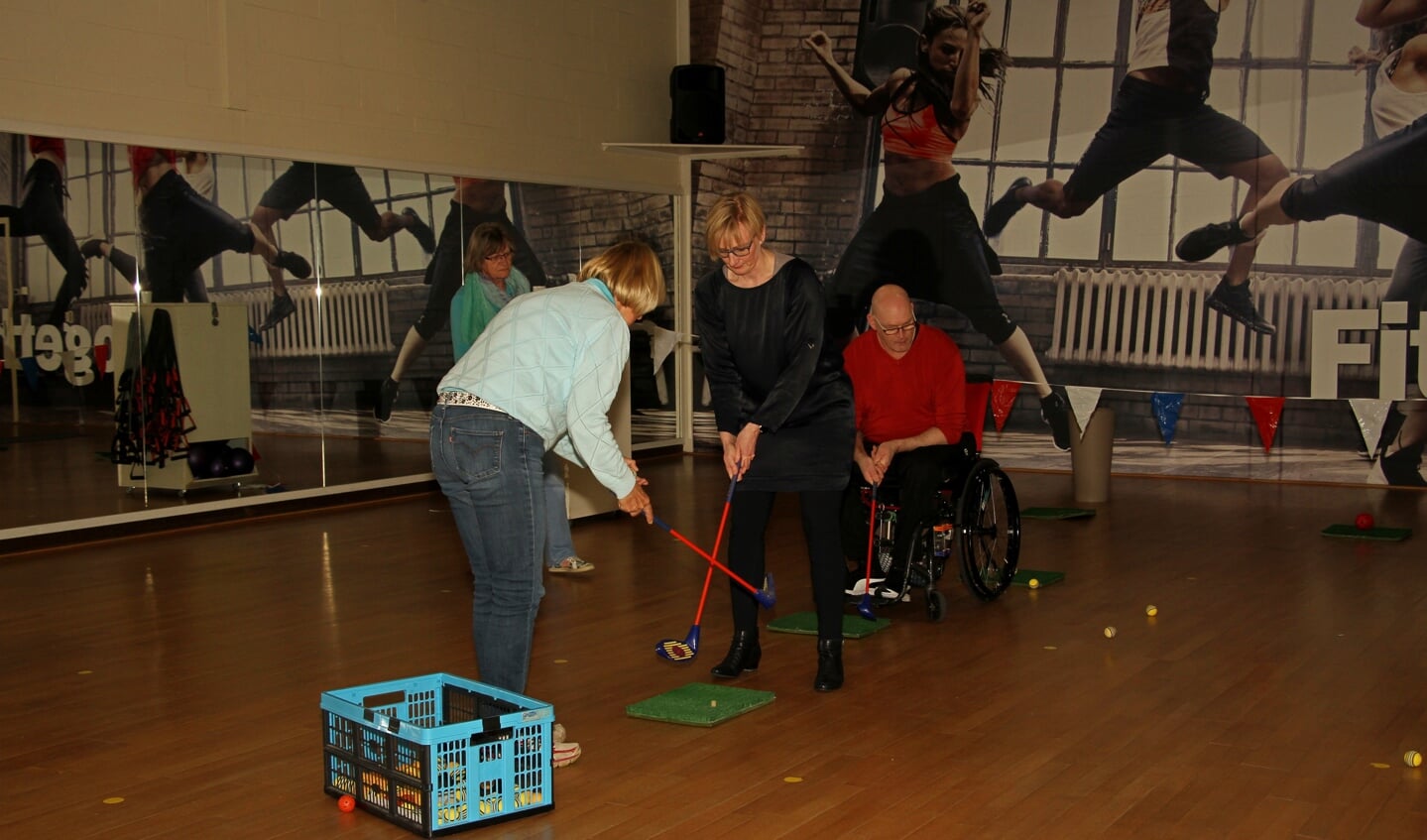 Burgemeester Besselink krijgt les in golf. Foto: Liesbeth Spaansen