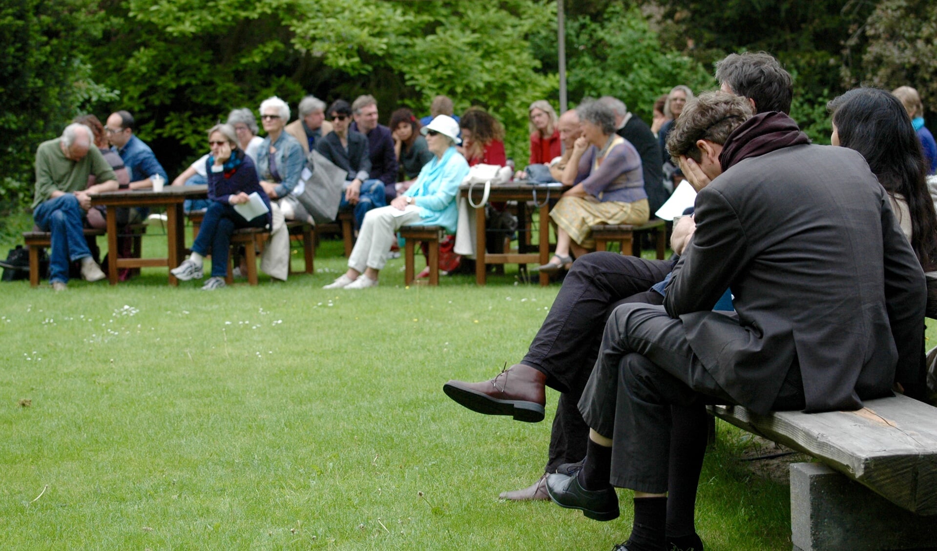 Publiek luistert naar de voordracht van één van de honderd voorlezers. Op de voorgrond dichter Erik Lidner. Foto: Nadine Ancher
