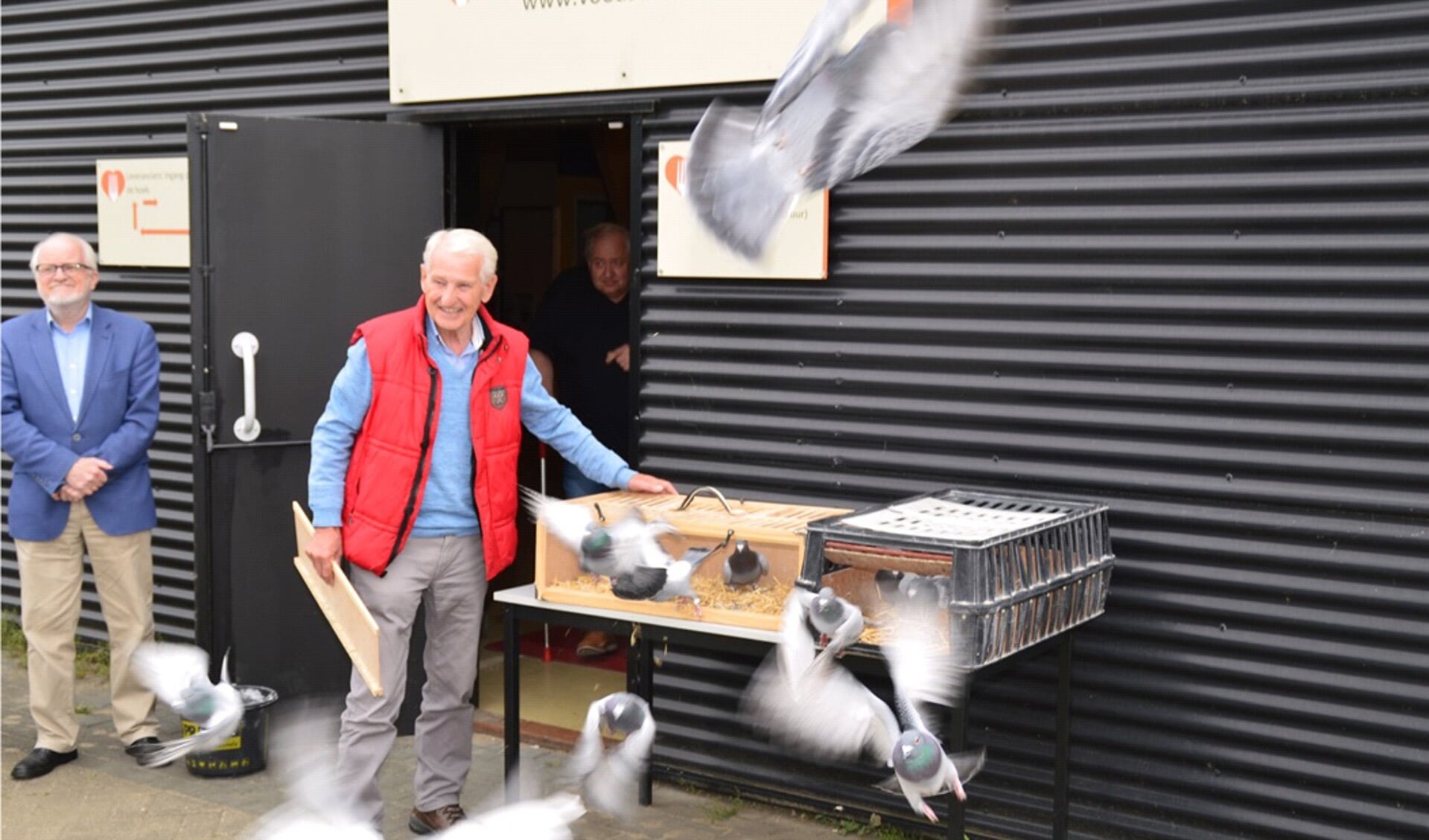 Gert Vrieze (l), voorzitter van de Voedselbank regio Zutphen, kijkt trots toe, terwijl duivenmelker Paul Troost uit Ellecom de duiven loslaat als symbool van hoop voor de toekomst. Foto: Henk Visscher