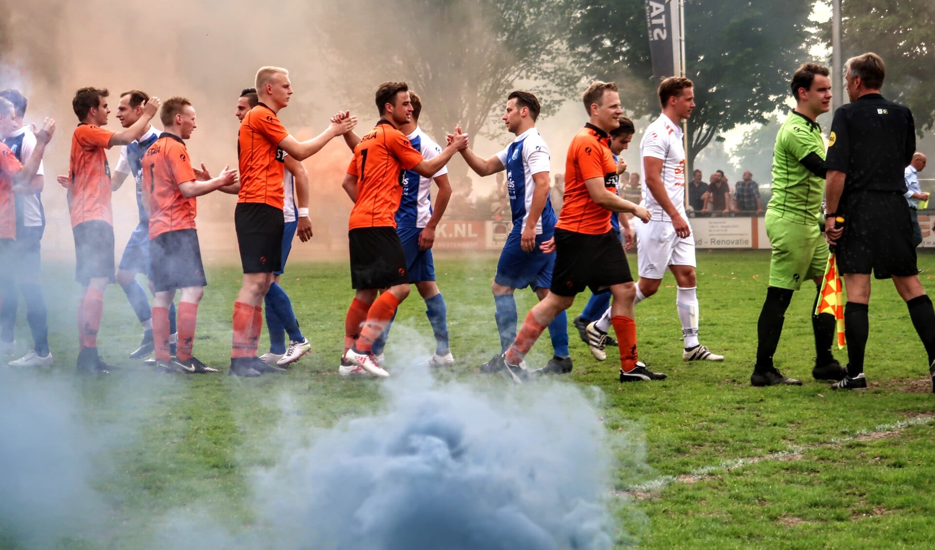 Oranje en blauwe rook zorgden voor een echte voetbalsfeer, kort voor de aftrap van Keijenburgse Boys-Pax. Foto: Luuk Stam
