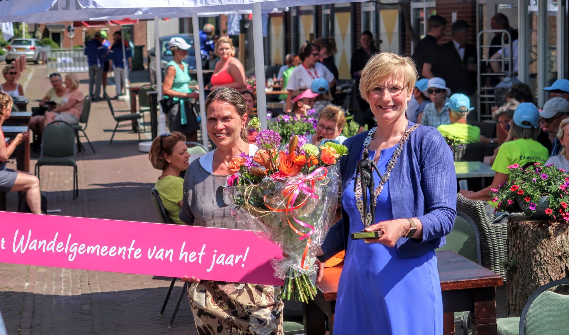 Burgemeester Marianne Besselink toont het beeldje dat hoort bij de titel Wandelgemeente van het jaar 2018. Foto: Luuk Stam 