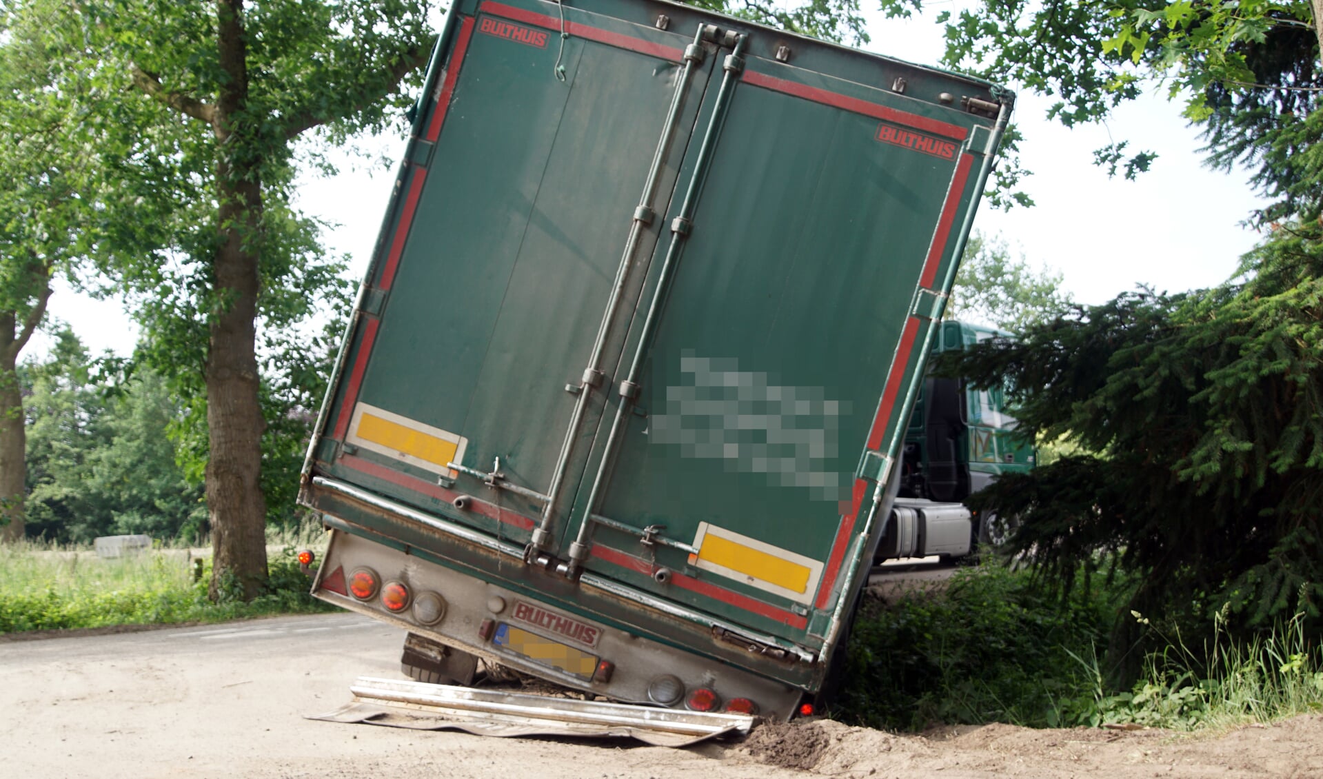 De oplegger van de vrachtwagen kwam vast te zitten in de berm en de sloot. Foto: GinoPress