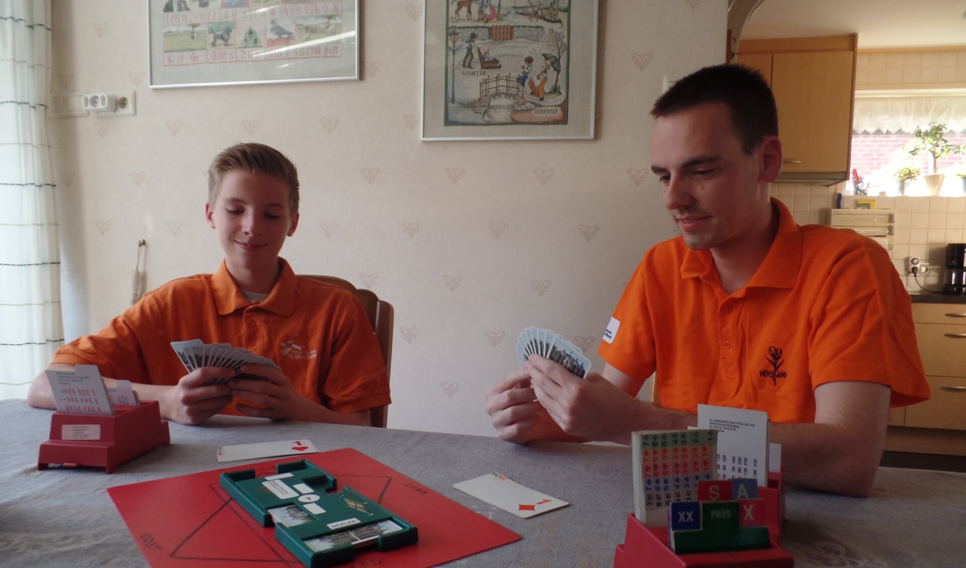 Kevin Gotink (rechts) en Jorn Essink doen aan de keukentafel van de familie Gotink uit de doeken dat je bridge speelt samen met een partner die tegenover je zit en tegen twee tegenstanders. Foto: Jan Hendriksen 