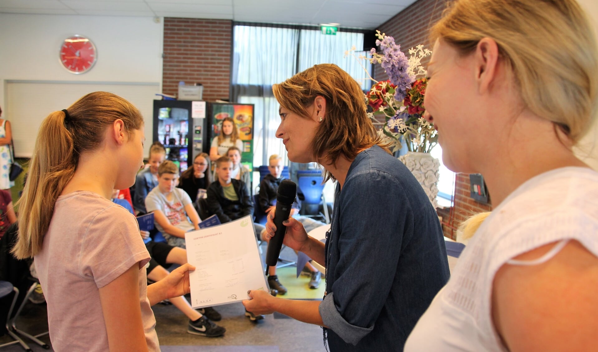 Ilse Saris (midden) en Melanie Vinkenvleugel bekijken samen met leerlinge Elke Nijenhuis het certificaat. Foto: Lydia ter Welle