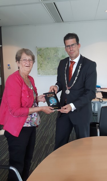 Margreet Boot en burgemeester Joost van Oostrum met het Engelstalige boek van Margreet. Foto: PR