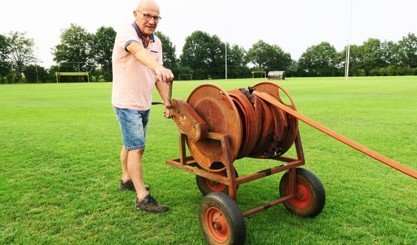 Vrijwilliger Willy Ribbers druk in de weer met het besproeien van de velden. Foto: Theo Huijskes