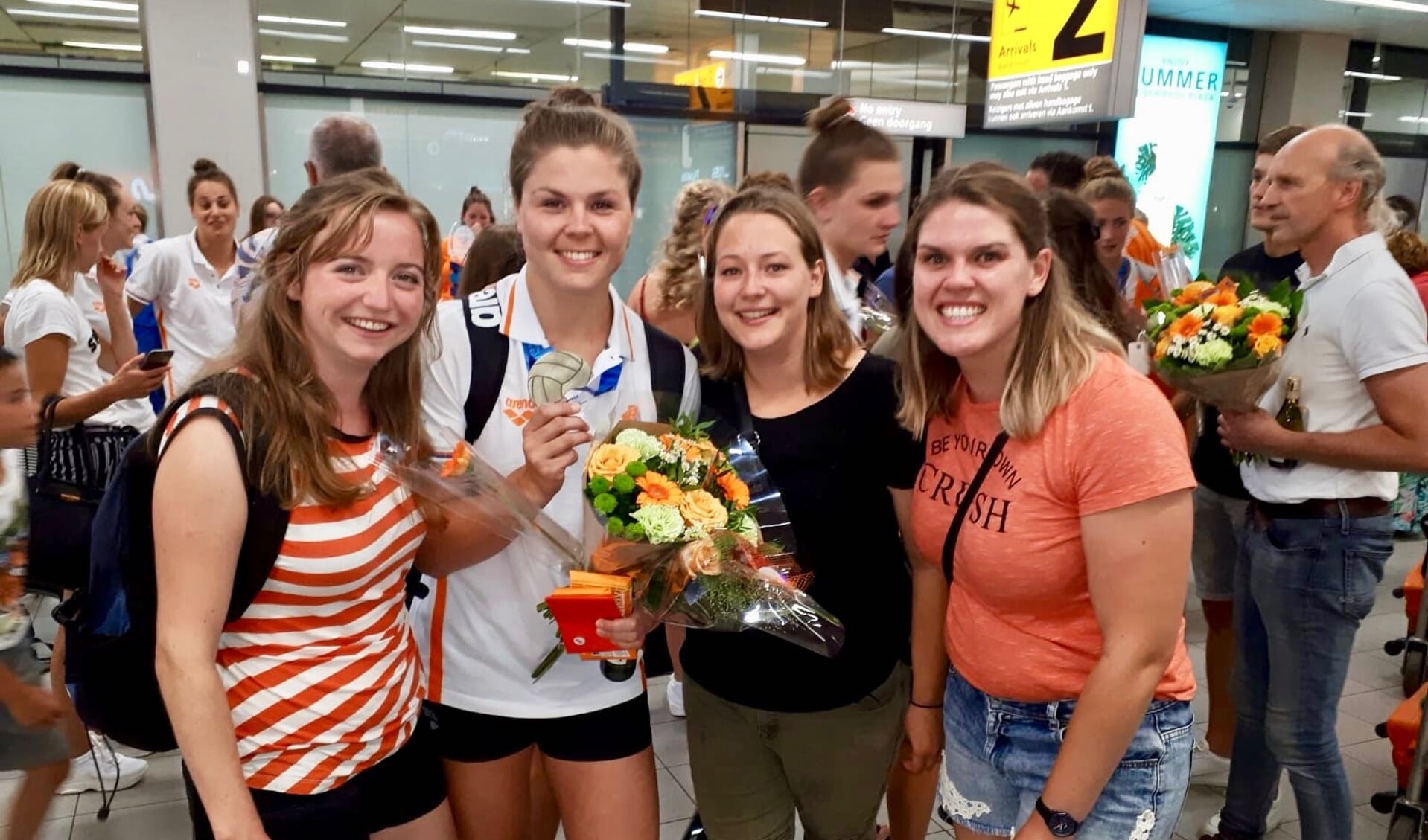 Vivian met medaille te midden van haar vriendinnen Nienke Harbers, Joyce Peper en Selynn Fiering, die haar onthaalden op Schiphol. Foto: eigen foto