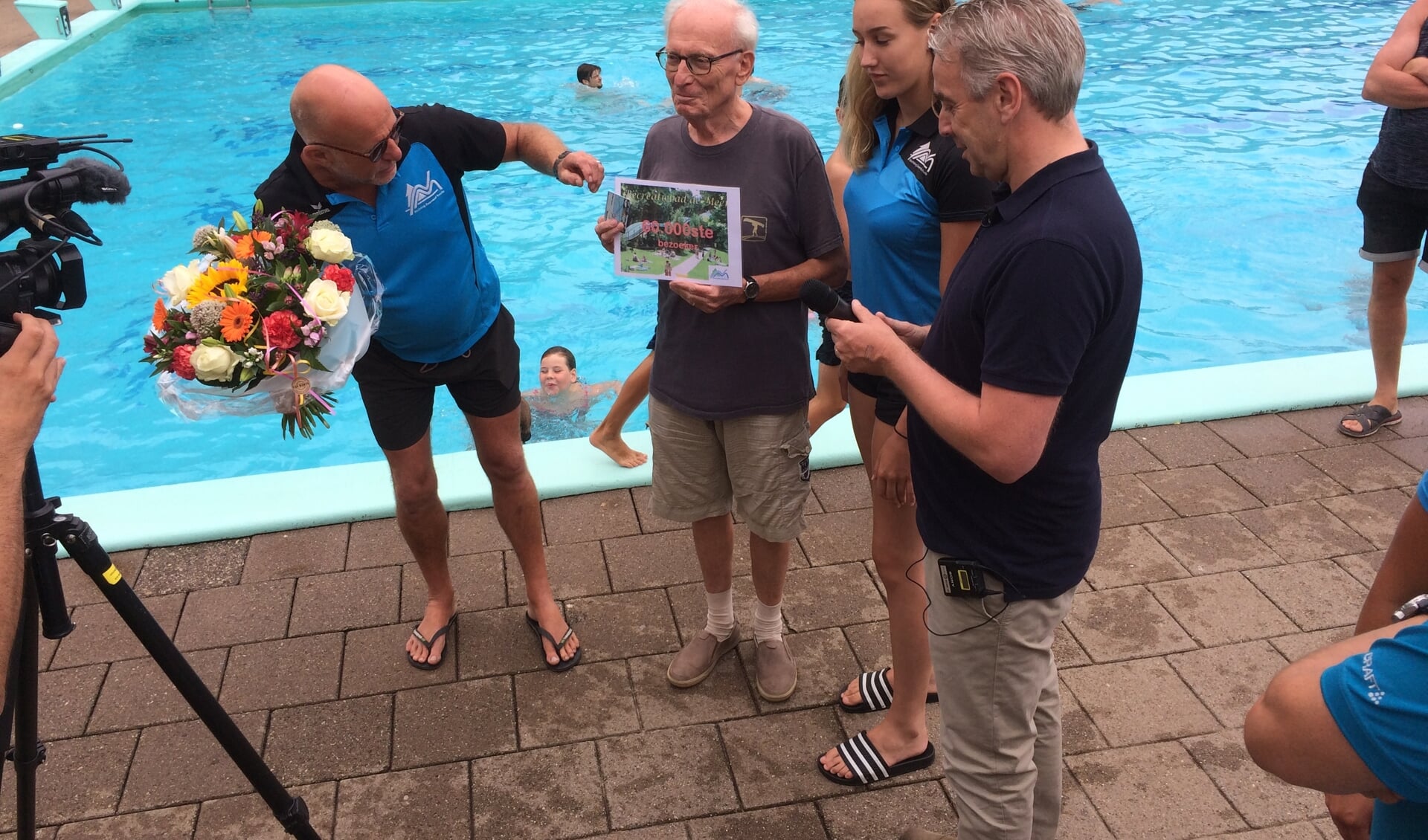 Hein Scholten wordt door het bad personeel van De Meene en het bestuur van Stichting Zwembad Ruurlo in het het zonnetje gezet. Foto: PR