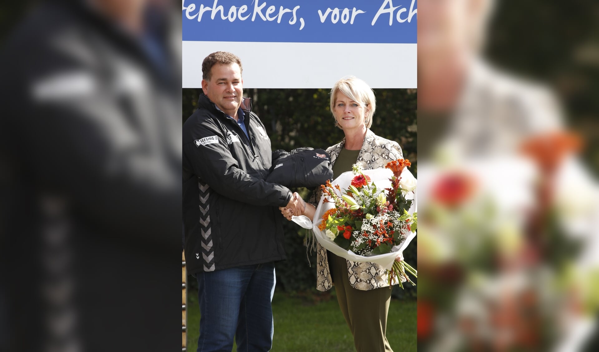 Sabine ten Holder wordt in de bloemen gezet door Eric Hummelink, als dank voor de sponsoring. Foto: Henk Plass