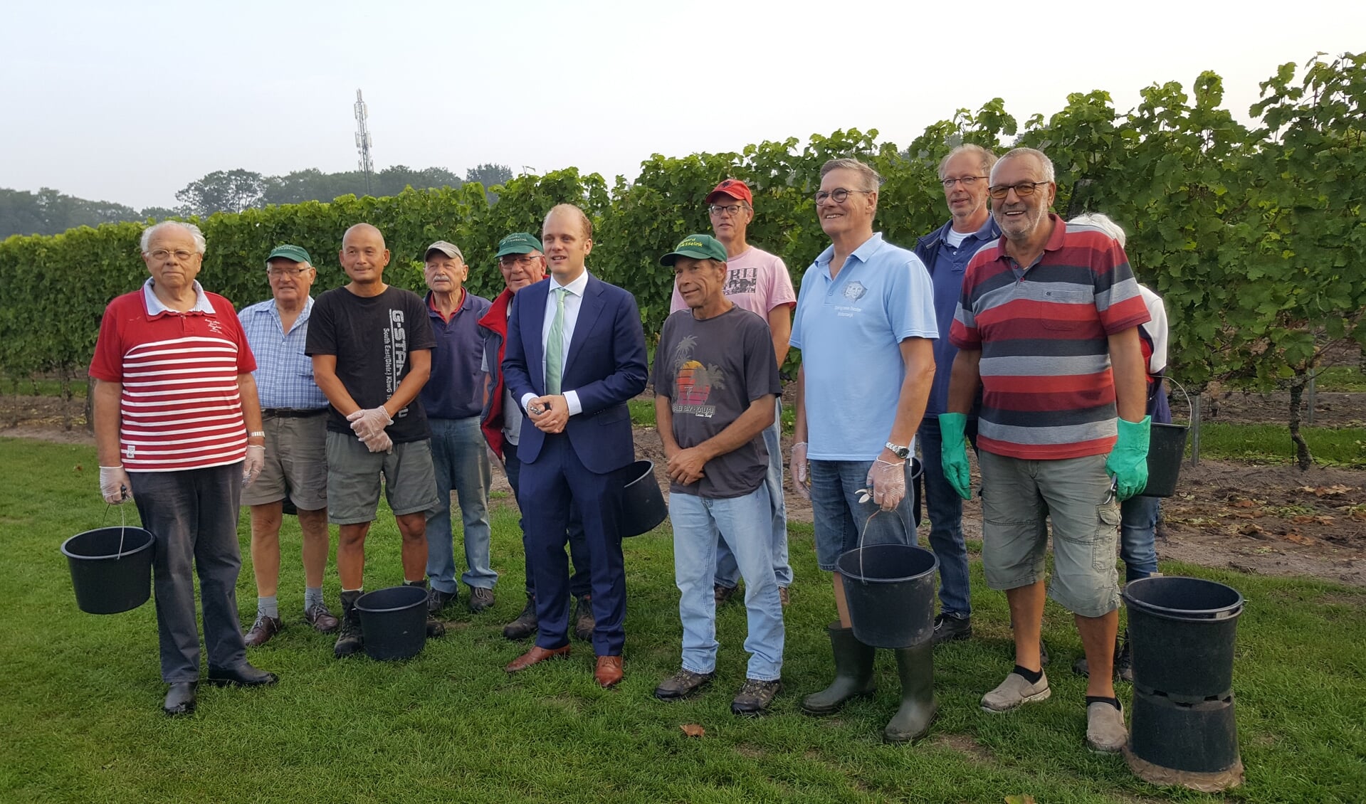 De druivenplukkers van Wijngaard Hesselink met burgemeester Bengevoord. Naast hem Gerhard Ensing. Foto: Wijngaard Hesselink
