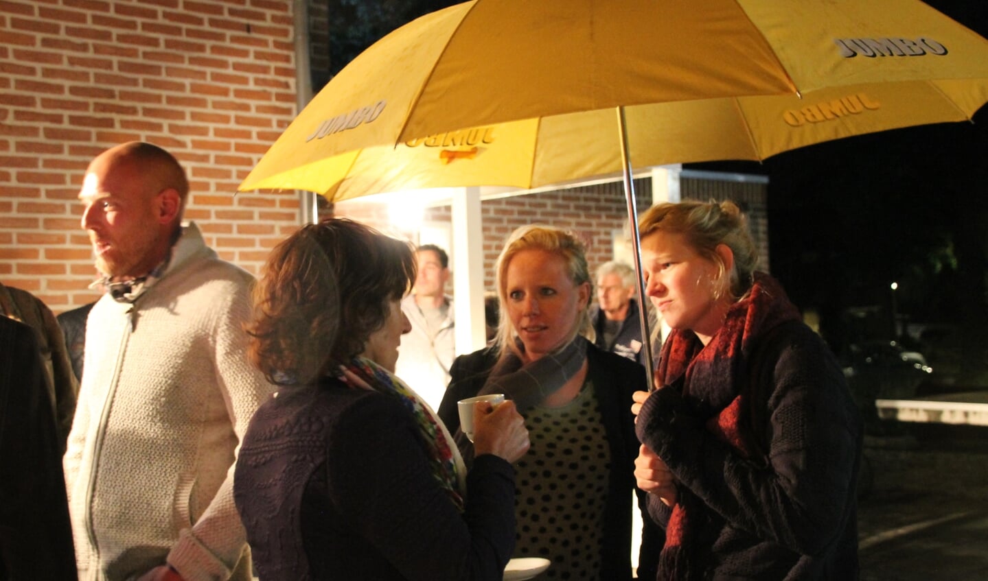 Samen schuilen en warmen aan een kopje koffie onder de paraplu. Foto: Annekée Cuppers