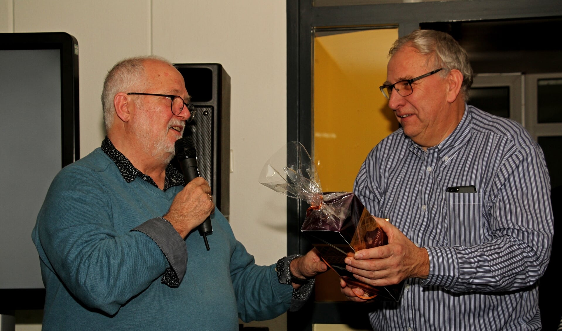 Meester Henny Barnhoorn geeft zijn collega en vriend meester Jan Burgers een afscheidscadeau. Foto: Liesbeth Spaansen