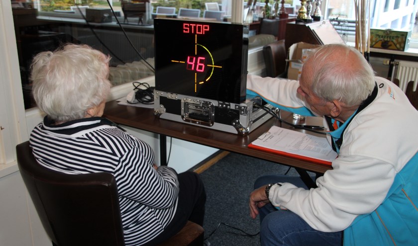 VVN-vrijwilliger Bennie Stronks neemt een reactietest af bij mevrouw Geling, die prima presteert tijdens deze test. Foto: Lydia ter Welle