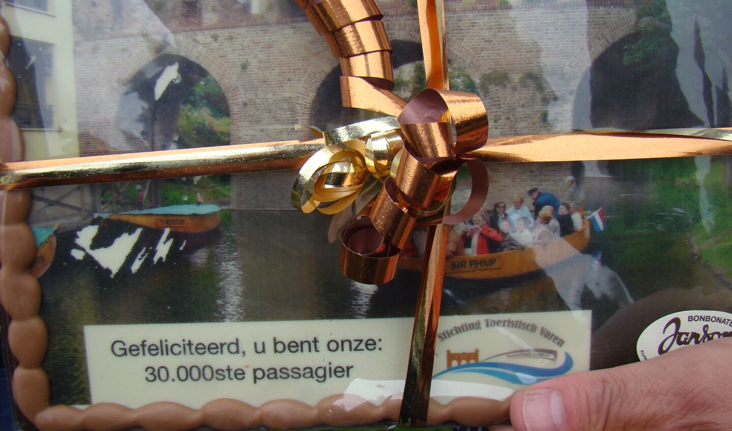 Het cadeau is een in chocolade uitgevoerde scene met fluisterboot en Berkelpoort. Foto: Mevrouw Eibrink is de 30.000ste passagier in 2019 en wordt feestelijk begroet door voorzitter Bouwhuis. Foto: Geert Joosten