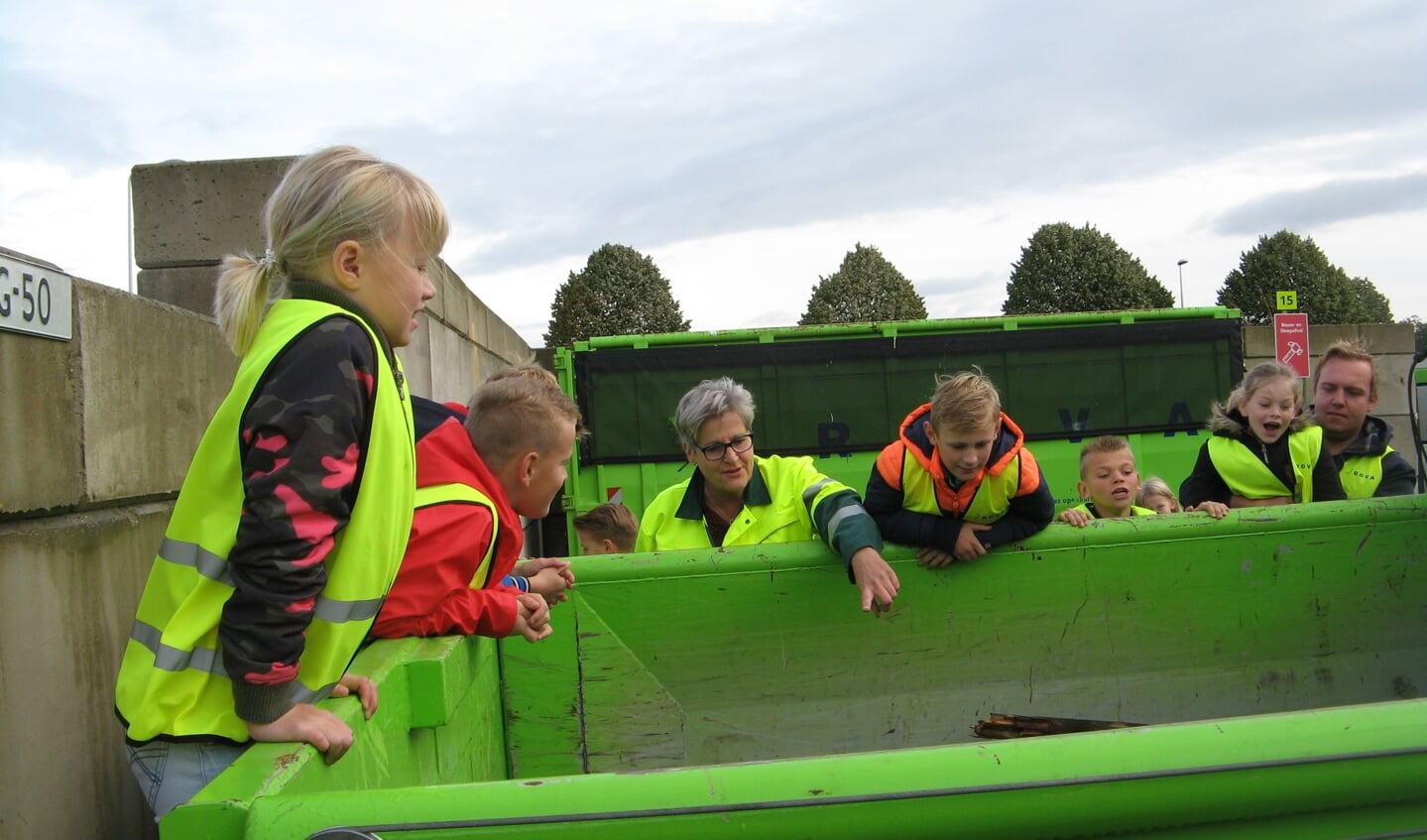  Leerlingen van groep 6 van de Sint Willibrordus-school werpen onder toeziend oog van Rova-onderwijzeres Dirry Lageschaar een blik in de container voor geïmpregneerd hout .Foto: Bart Kraan