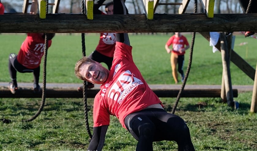 Deelnemers trotseren hangend aan hun armen de monkeybars. Foto: Hugo Rijkse