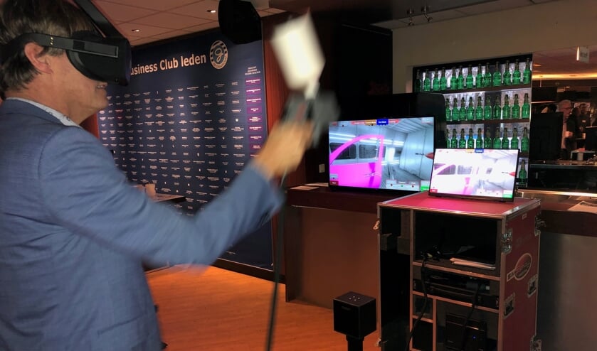 Met een VR-bril op waant de deelnemer aan het STERA event zich in een spuitcabine. Met de verfspuit in de hand ‘kleurt’ hij de autodeur. Foto: Miriam Szalata.