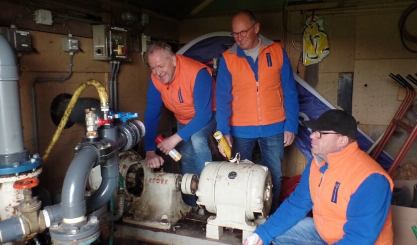 Hans Wullink, Jan Teeuwen en Laurens Bouwmeister (v.l.n.r.) bij de pompen voor de 'bypass' die IJsvereniging Vorden heeft aangelegd. Foto: Jan Hendriksen.