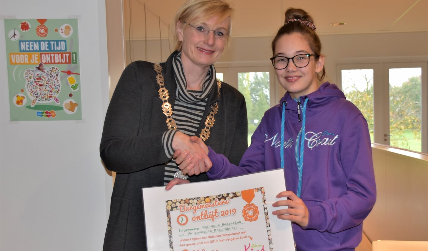 Levi Ribbink ontvangt de cheque voor Stichting Het Vergeten Kind uit handen van burgemeester Besselink. Foto: Alice Rouwhorst