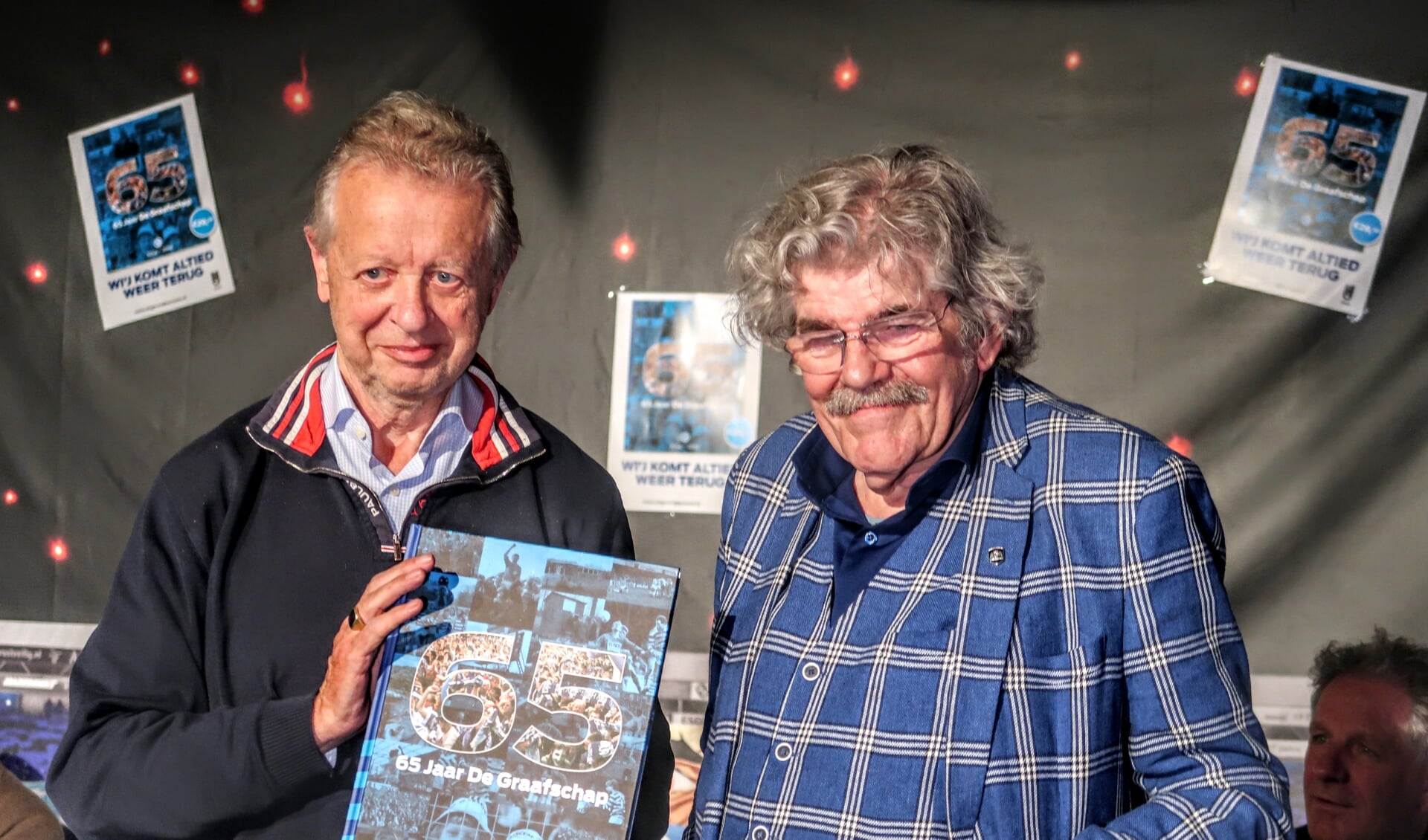 Supporter Jan Lamers (links) nam tijdens de boekpresentatie uit handen van Bennie Jolink het eerste exemplaar in ontvangst. Foto: Luuk Stam