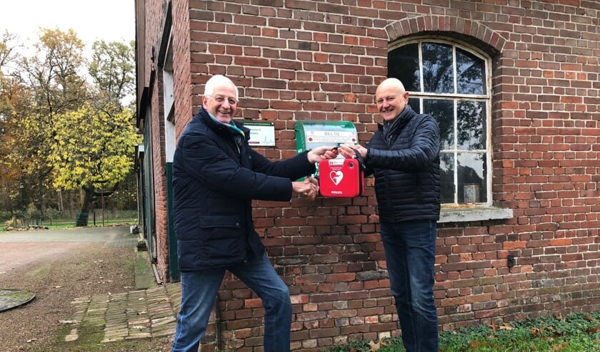 De overhandiging van de buurt-AED bij Smid Laar aan de Ratumseweg, links initiatiefnemer Willy Oortgiese, rechts Wim Kos, bestuurslid beheer Hart4Winterswijk. Foto: PR