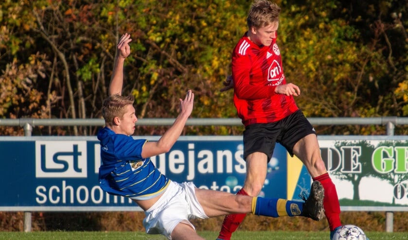 Tycho Riteco van Grol (in 't rood) in een duel met een speler van Luctor. Foto: Marcel Houwer