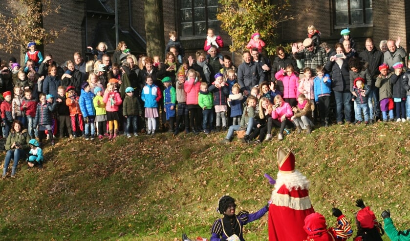 Honderden kinderen verwelkomen de Sint die per boot over de Grolse stadsgracht aankomt.