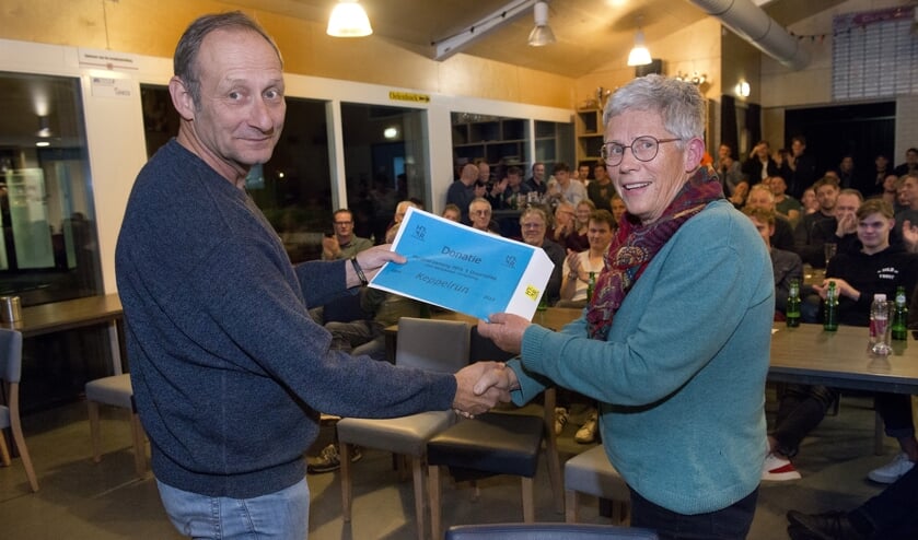 Irma van Hof overhandigt Mart de Kruif de cheque met de bijdrage voor verduurzaming van het sportpark. Foto: Wim van Hof