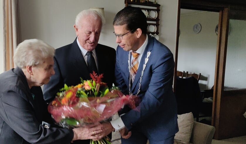 Het echtpaar Onstein-Annevelink bekijkt de bloemen die zij van burgemeester Joost van Oostrum hebben gekregen. Foto: Rob Stevens