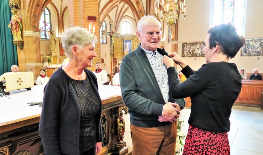 Voorzitter Grea Wolters van de locatieraad speldt jubilaris Herman Ueffing de versierselen op. Foto: Theo Huijskes