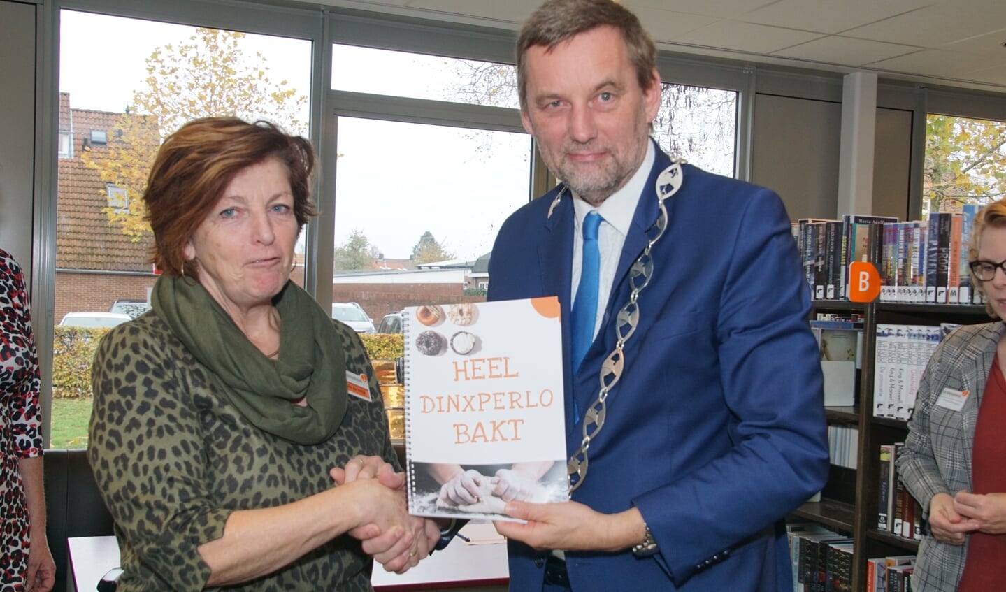Mieke de Vette overhandigt het eerste exemplaar aan burgemeester Anton Stapelkamp. Foto: Frank Vinkenvleugel