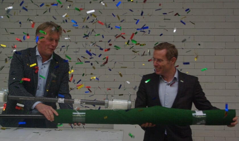 Eddy Gelhever en wethouder Willem Buunk openen het nieuwe centrum door een kunstgrasveld in te pakken. foto: Mirjam Rensink