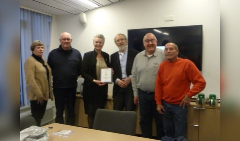 De activiteitenkalender van De Zonnebloem werd uitgereikt aan wethouder Van Haaren. Foto: PR