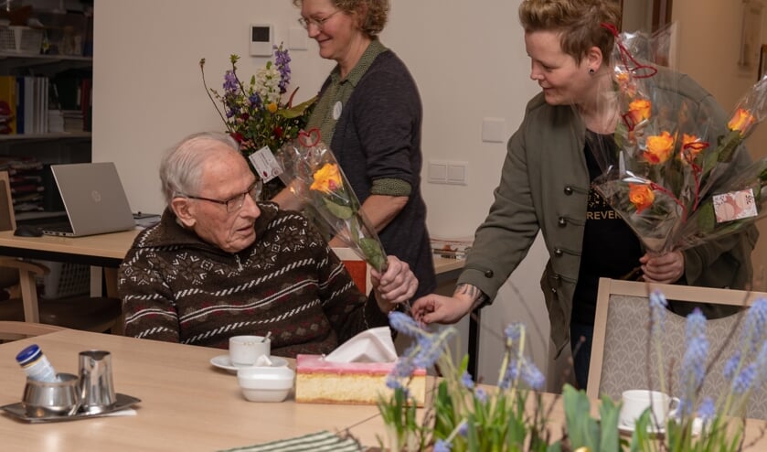 Debby van Aken geeft de heer W. Boeijink een roos. Op de achtergrond Ceciel Tankink. Foto: Rob Wanrooij