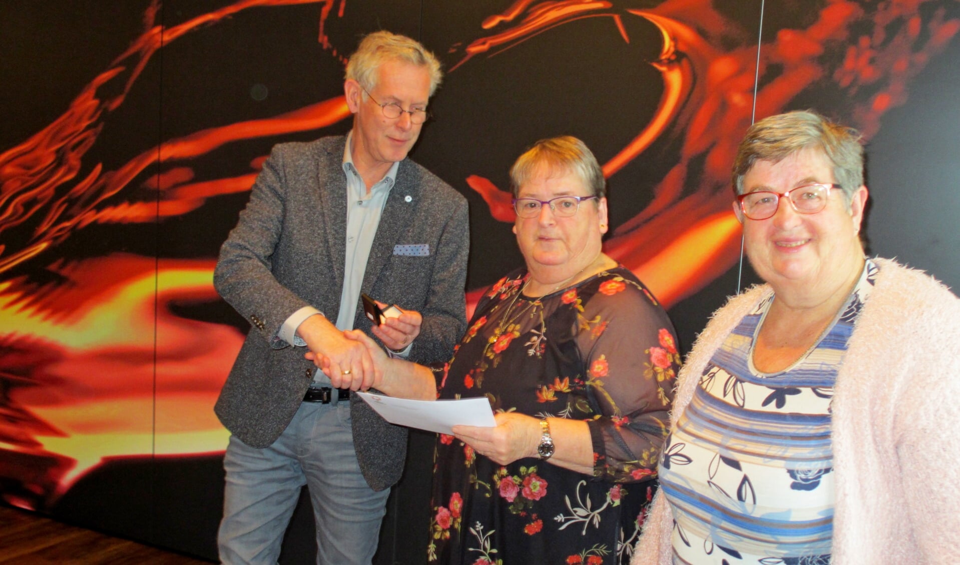Diny Hissink (m.) en Willy Kobussen ontvangen van bestuurder Gerrit Vlogman hun gouden Zonnebloem-onderscheiding. Foto: PR