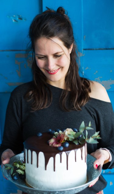 Colette van Deijzen doet échte bloemen op de taart. Foto: Carola Doornbos