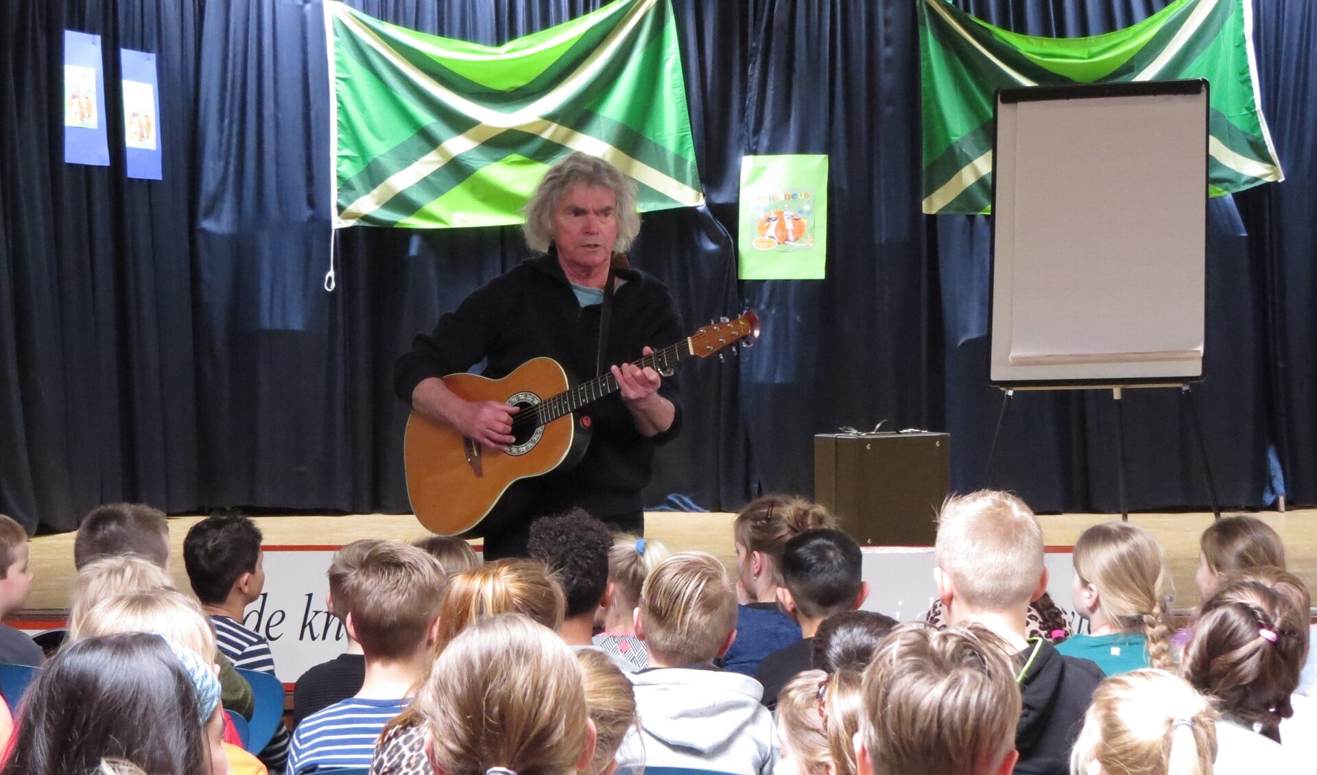 Hans Keuper weet kinderen van basisschool Op Koers te boeien met liedjes in het dialect. Foto: Josée Gruwel
