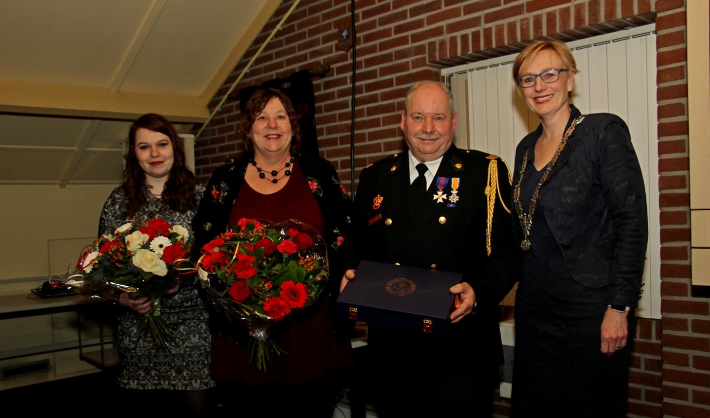 Burgemeester Marianne Besselink feliciteert Han Hobelman met zijn Koninklijke Onderscheiding. Zijn vrouw Ingrid en dochter Iris krijgen bloemen. Foto: Liesbeth Spaansen