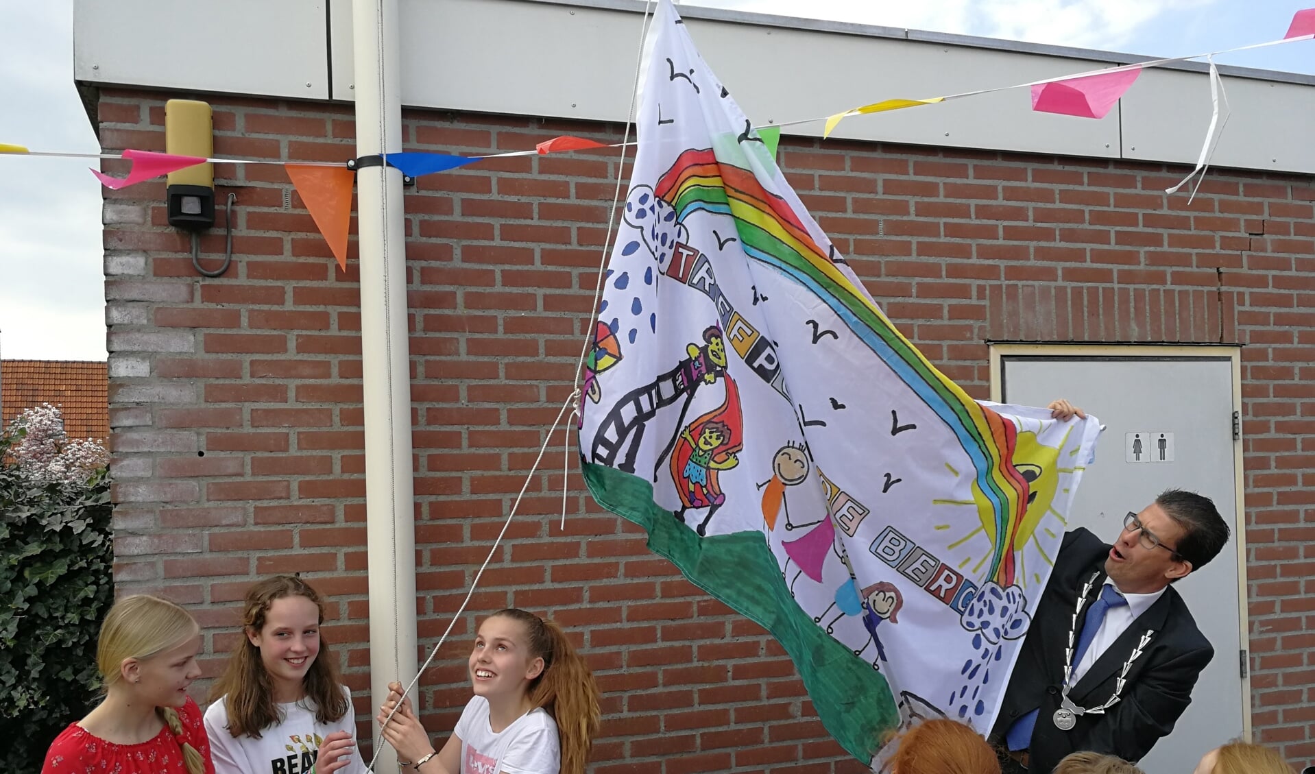 Burgemeester Van Oostrum hijst de vlag samen met Tess, Fleur en Lian. Foto: Rob Weeber