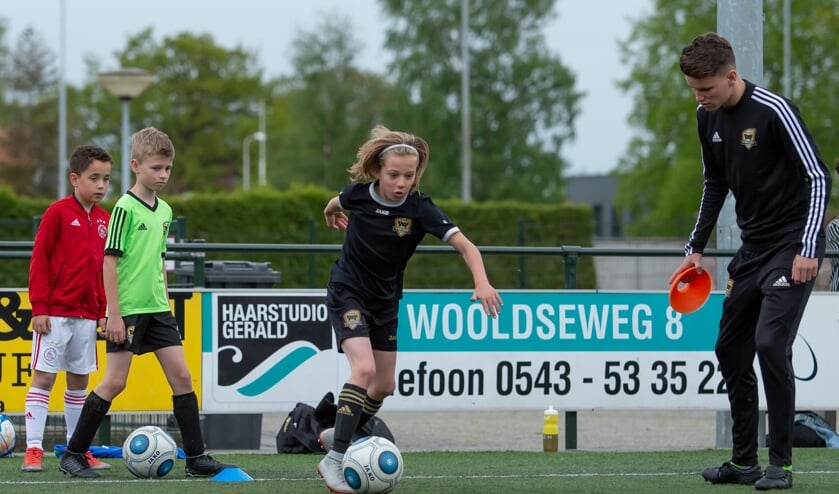 Rasmus in actie tijdens de training van FC Winterswijk JO10-1G, gadegeslagen door trainer Twan Meerdink. Foto: Marco ter Haar