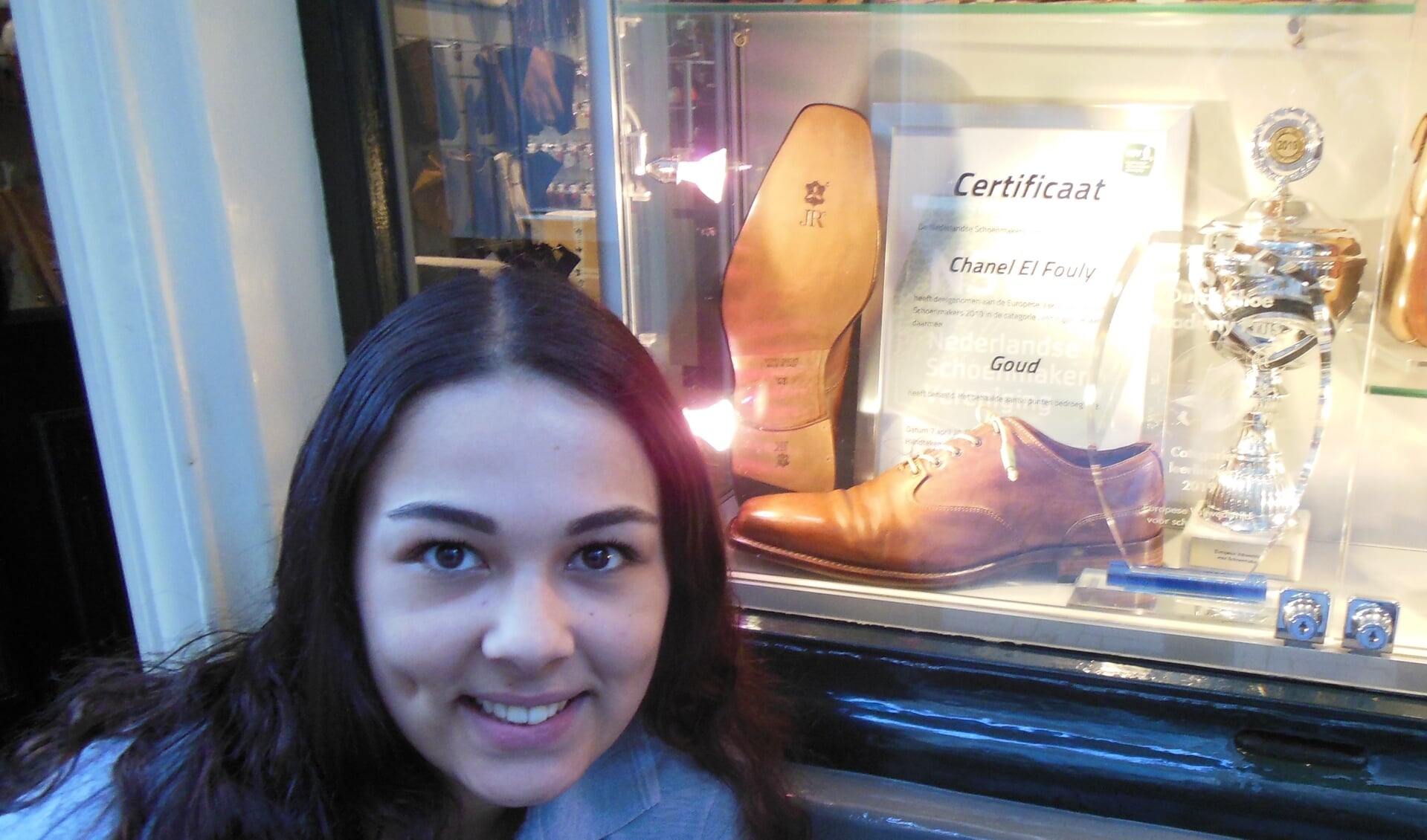 Chanel el Fouly voor de etalage van schoenmakerij ’t Centrum, waarin Mitchel Leijser, sinds 2017 eigenaar, speciale aandacht besteedt aan haar ambachtelijke topprestatie.  Foto: Eric Klop